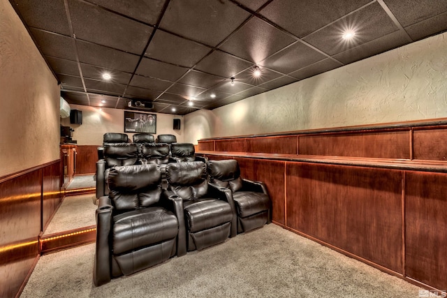 cinema room with light carpet, bar, wood walls, and a drop ceiling