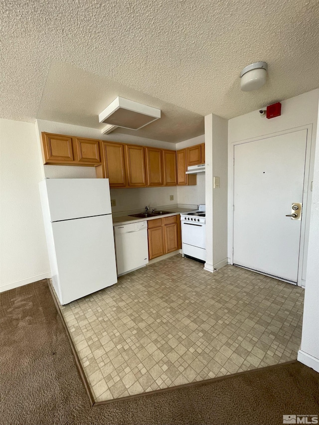 kitchen featuring white appliances, a textured ceiling, sink, and light colored carpet