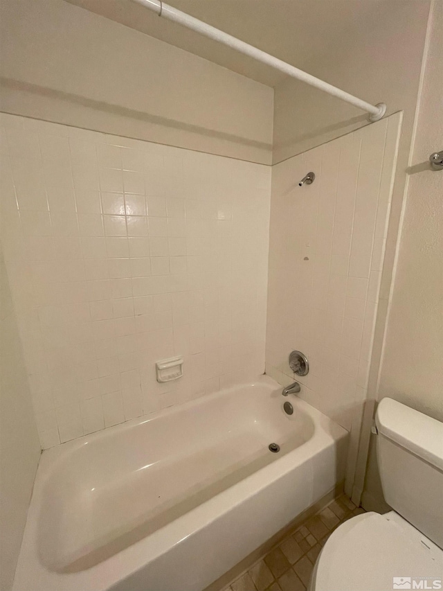 bathroom featuring tiled shower / bath, toilet, and tile patterned floors