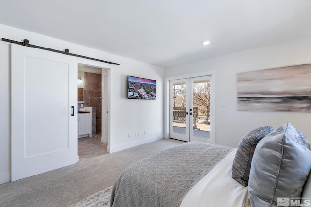 carpeted bedroom featuring a barn door, access to exterior, french doors, and ensuite bath