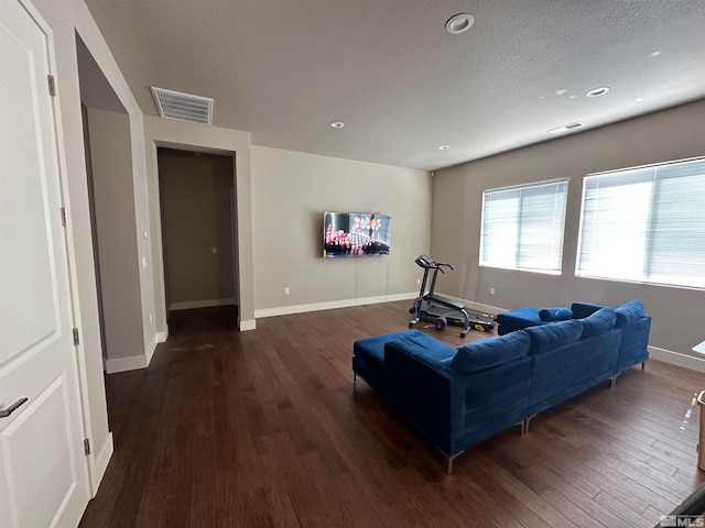 living room featuring a textured ceiling and dark hardwood / wood-style flooring