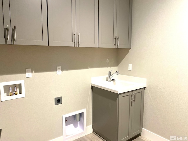 laundry area with cabinet space, baseboards, electric dryer hookup, washer hookup, and a sink