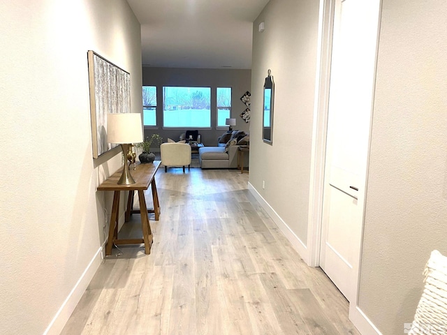 hallway featuring baseboards and wood finished floors