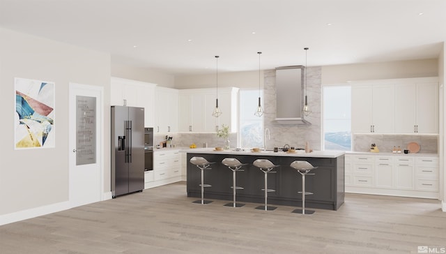 kitchen featuring hanging light fixtures, a center island, stainless steel fridge, light hardwood / wood-style floors, and white cabinets