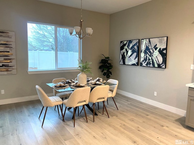 dining space with an inviting chandelier, light wood-type flooring, and a healthy amount of sunlight