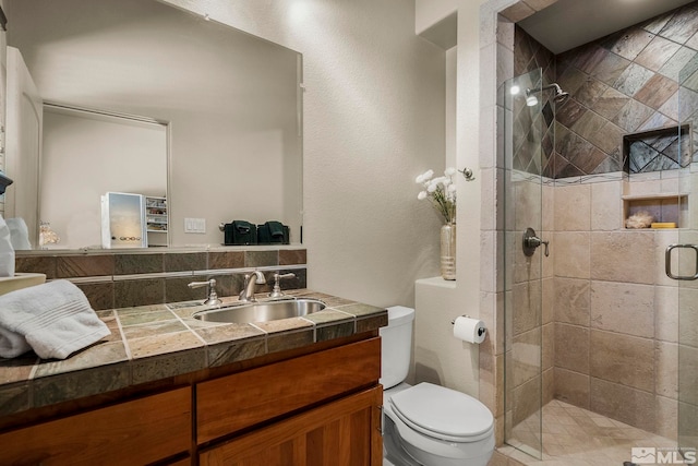 bathroom featuring vanity, toilet, and walk in shower