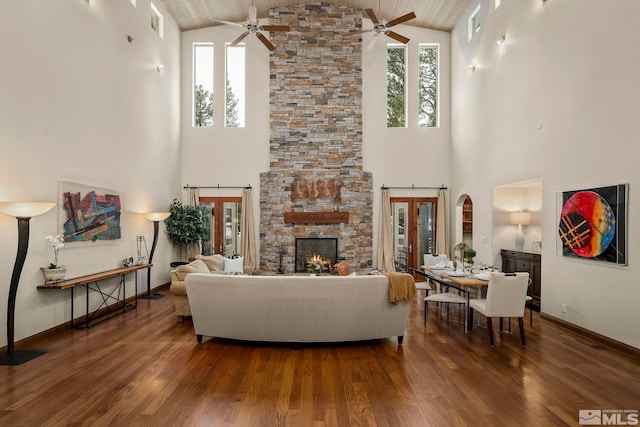 living room featuring a healthy amount of sunlight, ceiling fan, and dark hardwood / wood-style flooring