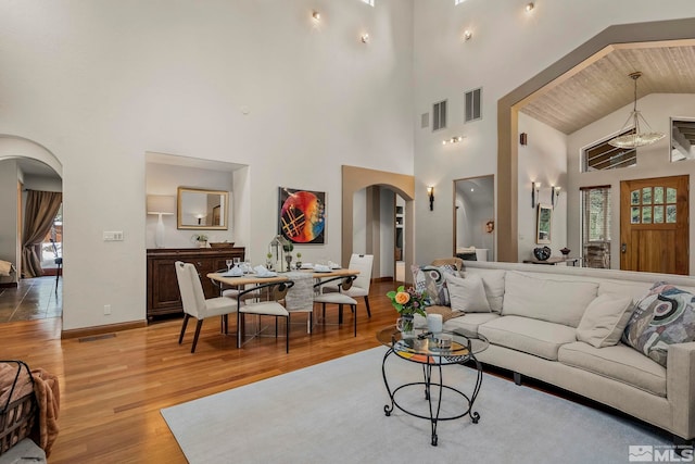 living room with light wood-type flooring and a high ceiling