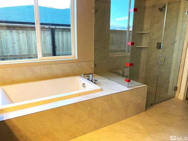 full bath with a stall shower, tile patterned flooring, and a bath