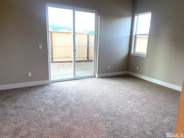 carpeted spare room with a wealth of natural light and baseboards