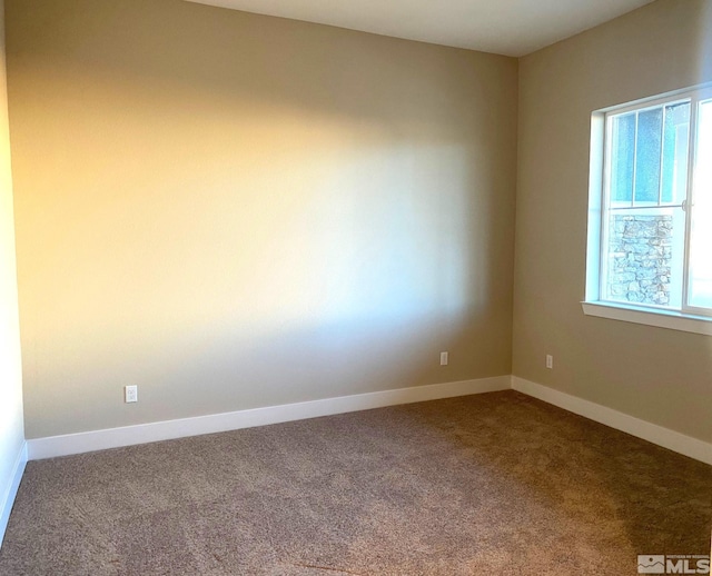 empty room featuring baseboards and carpet flooring