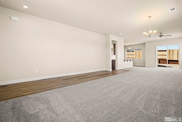 unfurnished living room featuring carpet and ceiling fan with notable chandelier