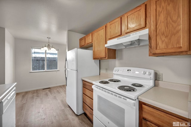 kitchen with an inviting chandelier, decorative light fixtures, light hardwood / wood-style flooring, and white appliances