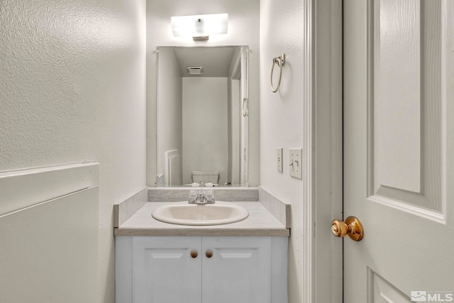 bathroom featuring toilet and vanity