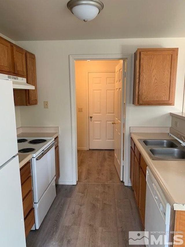 kitchen with dark wood-type flooring, sink, and white appliances