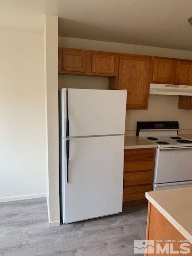 kitchen featuring light hardwood / wood-style flooring and white appliances