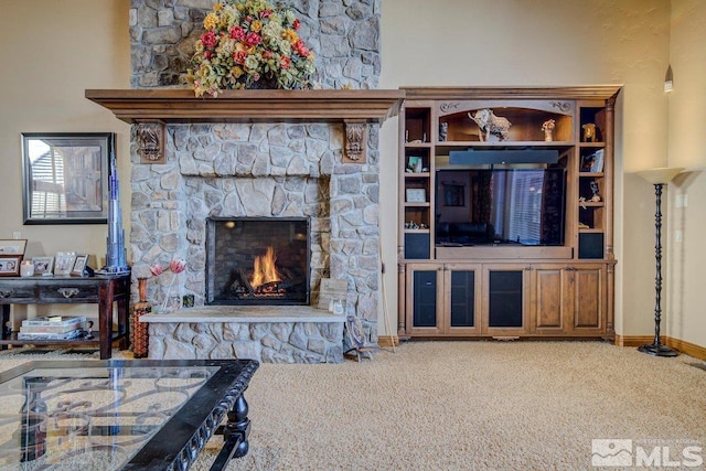 living room with carpet and a stone fireplace