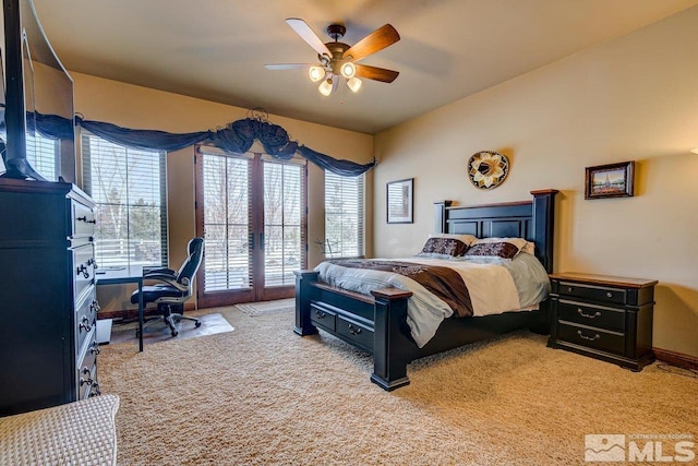 bedroom with light colored carpet, ceiling fan, and french doors