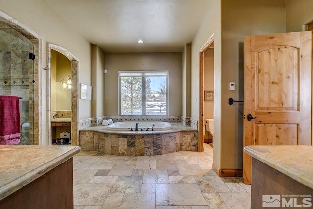 full bathroom featuring shower with separate bathtub, toilet, tile floors, and vanity