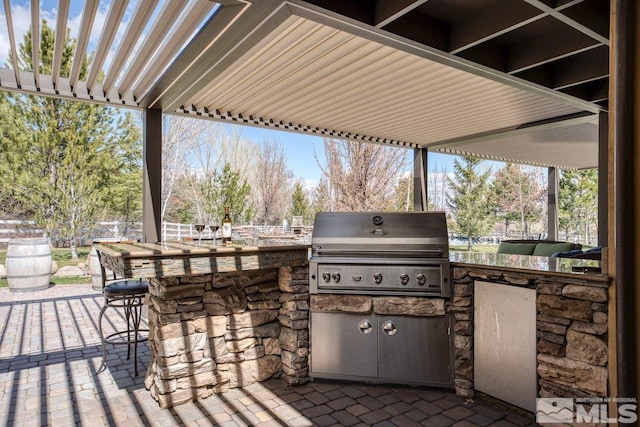 view of terrace featuring area for grilling, a pergola, and an outdoor bar