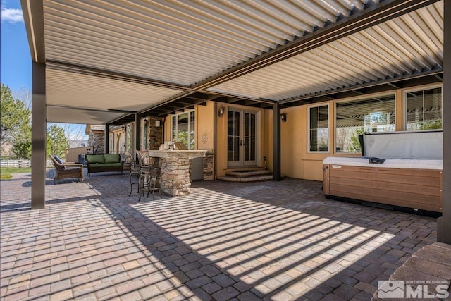 view of patio / terrace featuring a hot tub and exterior bar