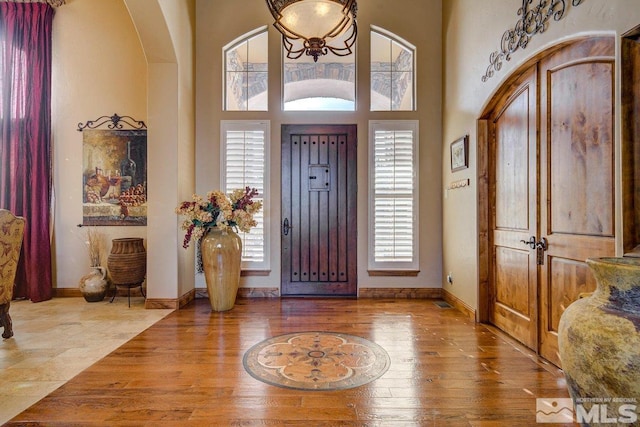 entrance foyer with plenty of natural light, a high ceiling, and light hardwood / wood-style flooring