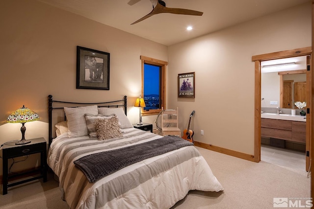 bedroom with ceiling fan, sink, light colored carpet, and ensuite bathroom