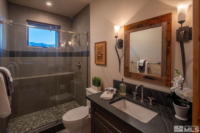 bathroom with toilet, an enclosed shower, and vanity