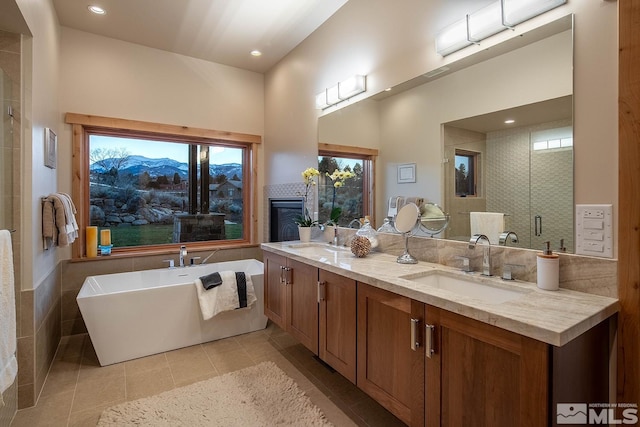 bathroom featuring independent shower and bath, dual bowl vanity, tile flooring, and a mountain view