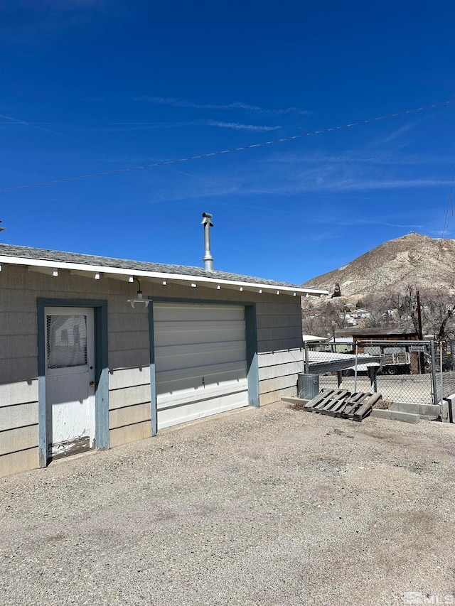 exterior space featuring central air condition unit, a garage, and a mountain view