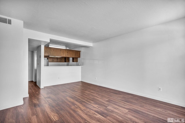 unfurnished living room with dark hardwood / wood-style floors and a textured ceiling