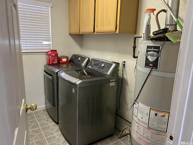 laundry area with cabinets, gas water heater, washer and dryer, and light tile patterned floors