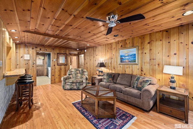 living room featuring wood walls, light hardwood / wood-style flooring, and wooden ceiling