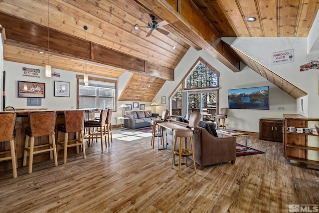 living room featuring hardwood / wood-style floors, ceiling fan, a healthy amount of sunlight, and beam ceiling