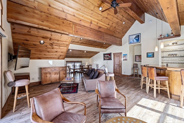 living room featuring vaulted ceiling with beams, light wood-type flooring, and ceiling fan