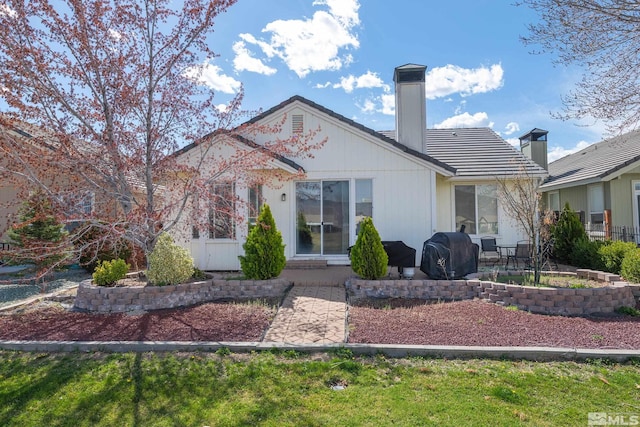 rear view of house with a lawn and a patio