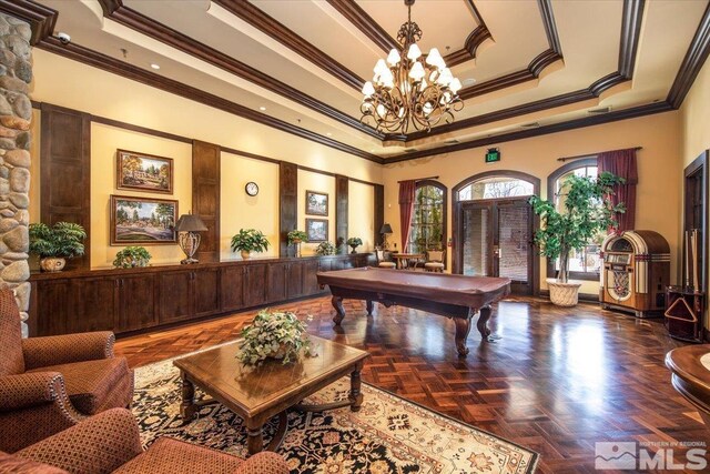 recreation room with a tray ceiling, dark parquet flooring, an inviting chandelier, ornamental molding, and pool table