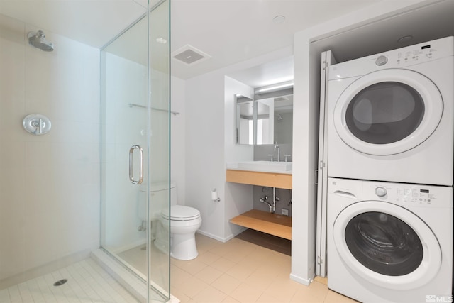 washroom with stacked washer and clothes dryer, sink, and light tile floors