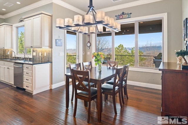 dining space featuring plenty of natural light, sink, dark hardwood / wood-style flooring, and crown molding