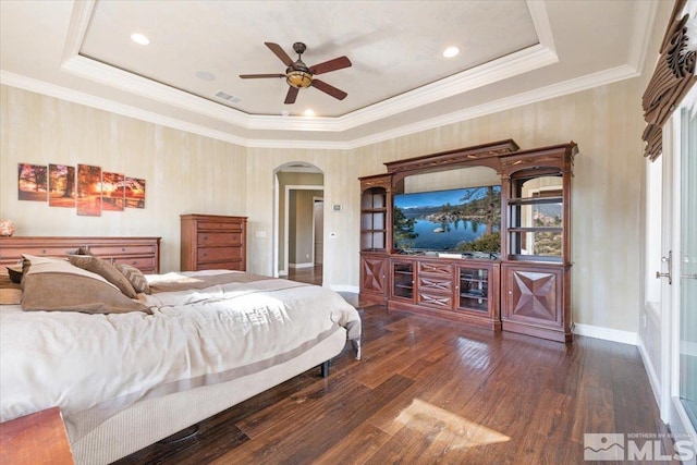 bedroom with ornamental molding, ceiling fan, a raised ceiling, and dark wood-type flooring