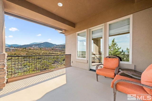 view of patio with a mountain view and a balcony