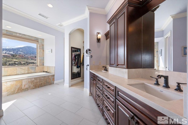 bathroom featuring large vanity, a mountain view, tiled tub, and tile flooring