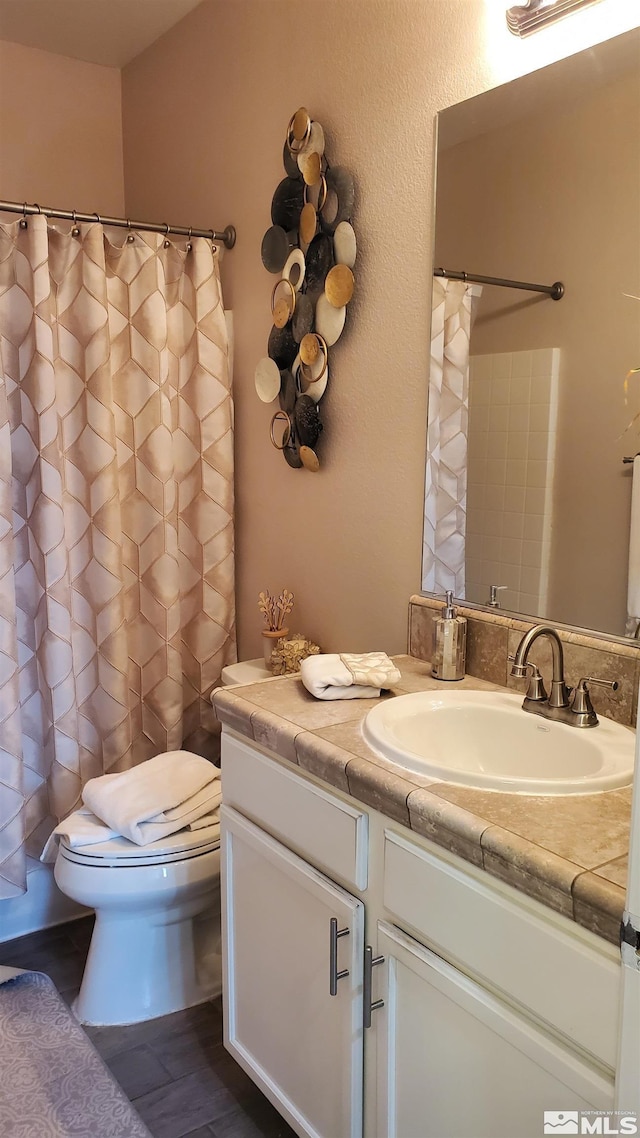 bathroom featuring hardwood / wood-style floors, large vanity, and toilet