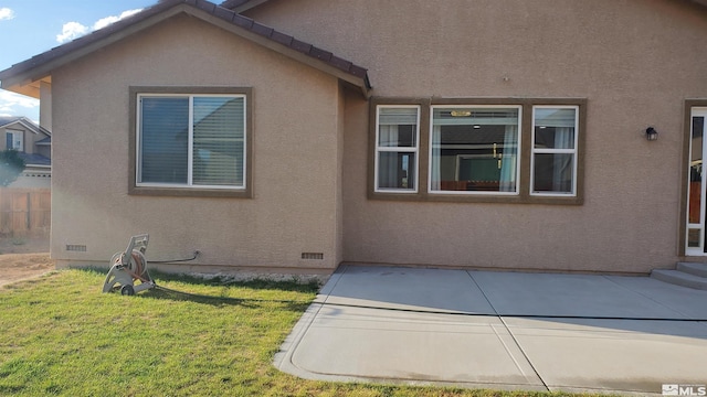 view of property exterior with a yard and a patio area