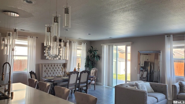 dining space with sink, wood-type flooring, and a textured ceiling