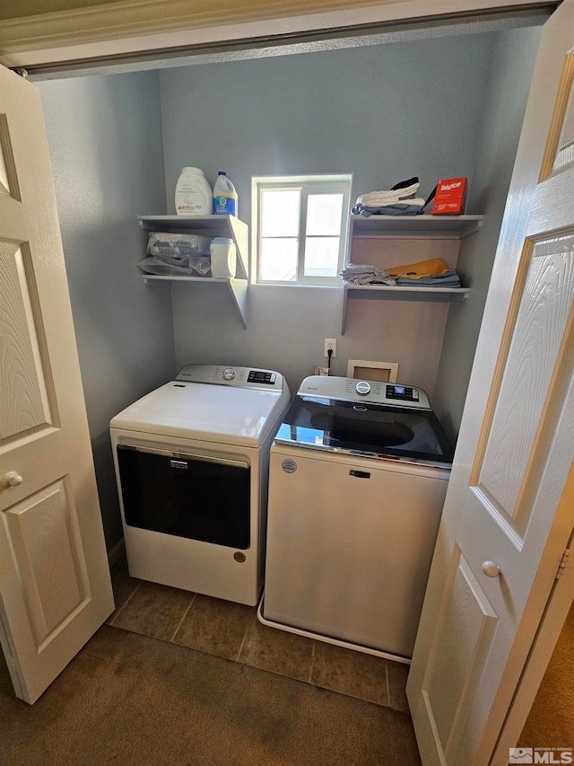 washroom featuring dark tile floors, washer hookup, and washer and clothes dryer