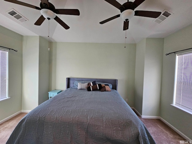 carpeted bedroom with ceiling fan and multiple windows