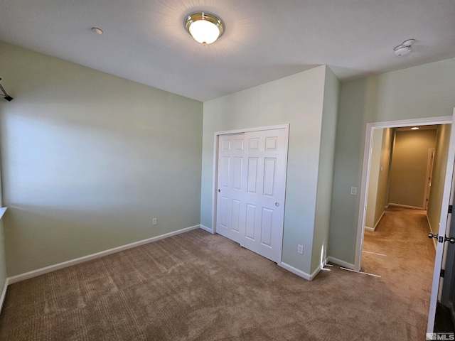 unfurnished bedroom with light carpet and a closet