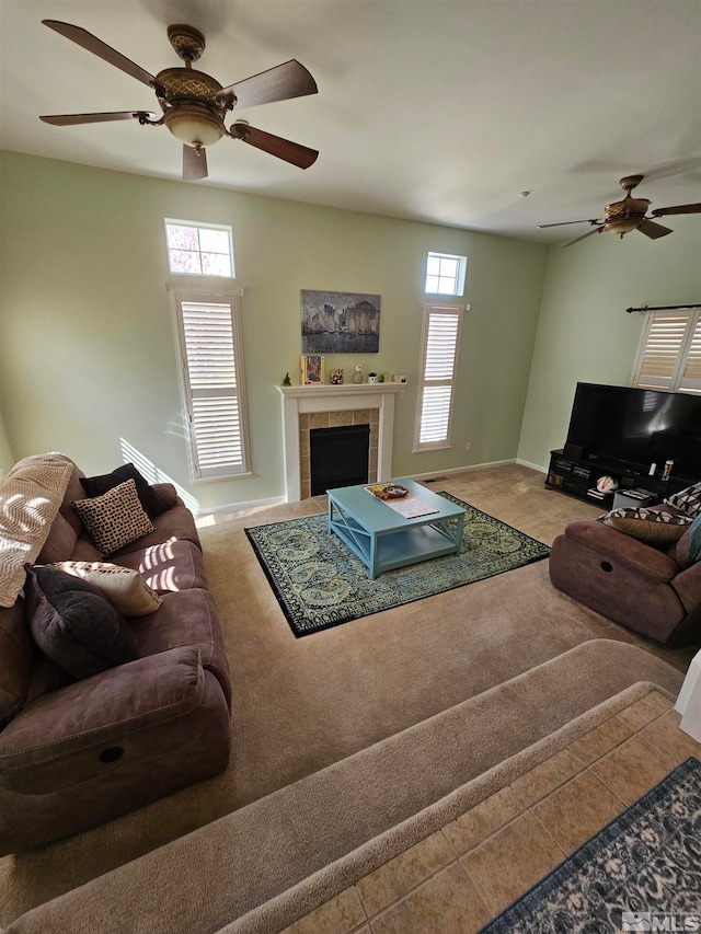 living room featuring ceiling fan and a tile fireplace