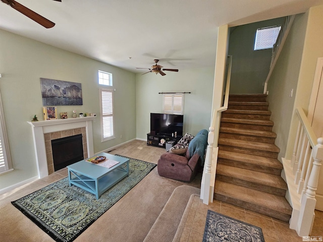 living room featuring ceiling fan, light tile flooring, and a tile fireplace